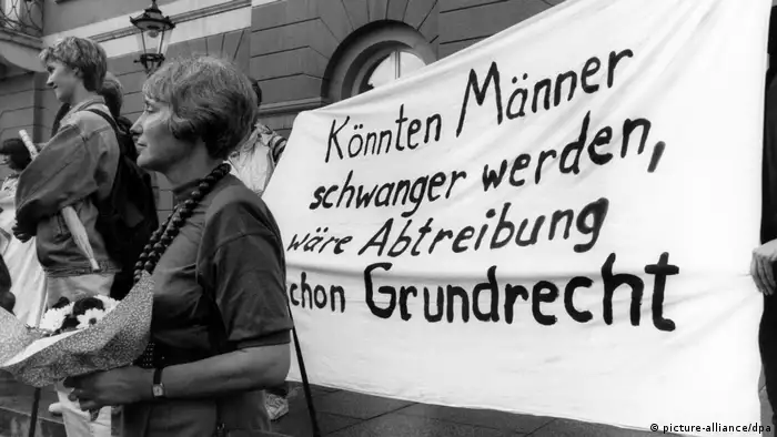 Women stand next to a banner that reads If men could become pregnant, abortion would already be a fundamental right in German. 