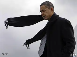 Barack Obama steps off a plane as his scarf blows in the wind