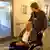 Ein Zivildienstleistender schiebt einen älteren Herren im Rollstuhl. (Foto: DW)