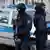 Policias alemães armados diante de viatura