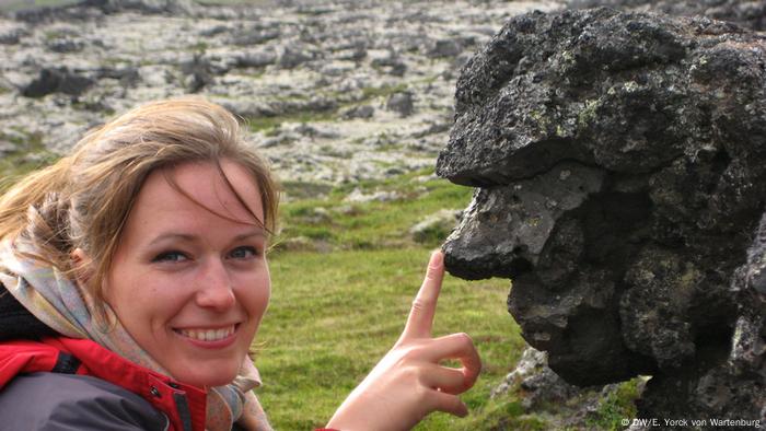 A tourist taps her finger on the nose of Hraunkarl in Iceland