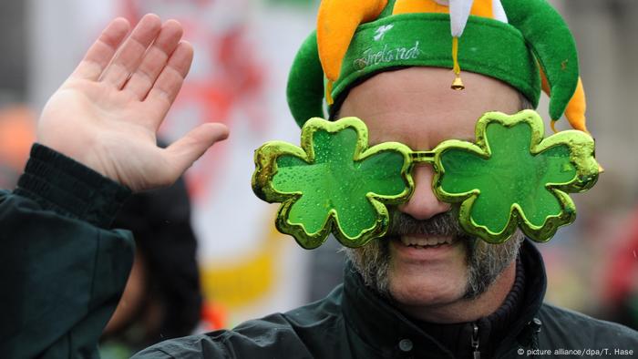 Un hombre luce enormes anteojos con tréboles en la fiesta del St. Patrick's Day.