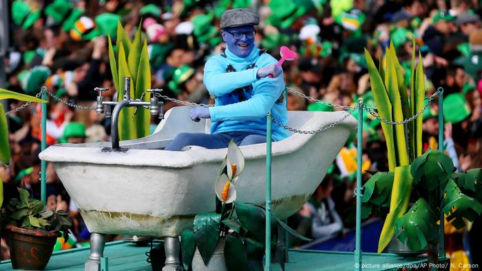 Un hombre disfrazado de azul, en una tina, en el desfile de St. Patrick's Day.