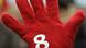 A striker's hand covered in a red glove with a white 8 on it A striker's hand covered in a red glove with a white 8 on it