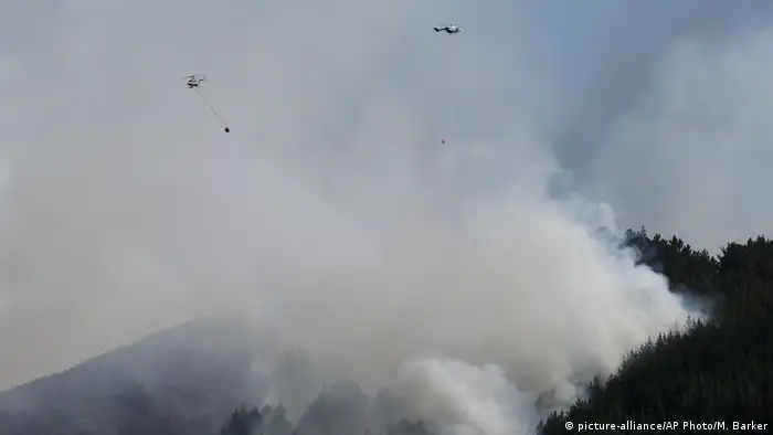 Two helicopters fight a wild fire in the Port Hills near Christchurch, New Zealand (picture-alliance/AP Photo/M. Barker)