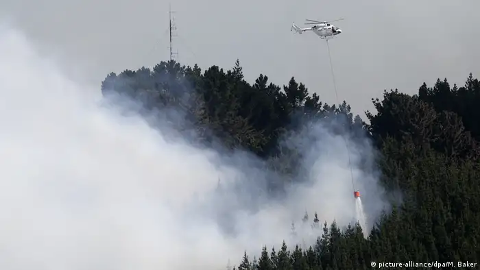 Helictoper dumps water on a smouldering fire (picture-alliance/dpa/M. Baker)