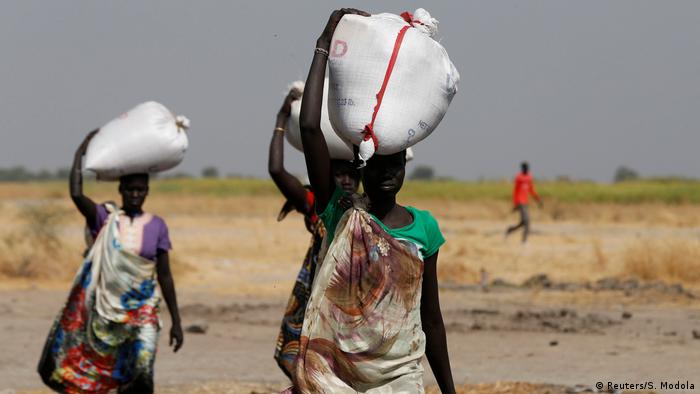 South Sudanese women carrying sacks of food