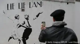 Mural in London by English street artist Bambi depicting British Prime Minister Theresa May dancing with US President Donald Trump under the words lie lie land