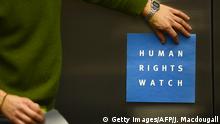 ARCHIV 2014 ***** A man puts a logo of US-based rights group Human Rights Watch on the wall as he prepares the room before their press conference to release their annual World report on January 21, 2014 in Berlin. The United States is setting a dangerous example for the world with its sweeping surveillance programmes run by National Security Agency NSA, giving governments an excuse for mass censorship of online communications, Human Rights Watch says in its 2014 report. AFP PHOTO / JOHN MACDOUGALL (Photo credit should read JOHN MACDOUGALL/AFP/Getty Images)