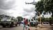 A man carrying groceries walks past police vehicles during a stand-off between Somali migrants and anti-immigrant protestors in Pretoria A man carrying groceries walks past police vehicles during a stand-off between Somali migrants and anti-immigrant protestors in Pretoria