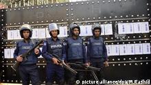 Bangladeshi police personnel stand guard in front of a shut garments factory at Ashulia outskirts of Dhaka, Bangladesh on December 21, 2016.
A total of 59 garment factories at Ashulia on the outskirts of Dhaka have been declared shut in face of labour unrest as thousands of workers were demonstrating for increased wages. Bangladesh Garment Manufacturers and Exporters Association (BGMEA) president Md Siddiqur Rahman made the announcement on behalf of the owners of the factories at a press conference at the BGMEA building on Wednesday. Speakers at the conference said the factories were shut down as per article 13 (1) of the labour law.
Workers of at least 10 factories went on strike, without resuming work on Monday morning.
Production came to a halt due to workers' strike at the factories De Rose, Pioneer, Washing Design, Palmal Group, Safa Knit, Dong Xiang and Envoy.
The workers alleged that they could not meet their family expenses with the current wages.
The last time they received a pay-hike was in 2013 and the minimum wage was fixed at Tk 5,300 a month.
However, the workers now demand Tk 15,000 a month.
The workers also alleged that they were not given gratuity and leave which they are entitled to. They even complained about harassment by the owners of the factories.
The workers in Ashulia began staging demonstration last Monday when workers of Windy Group went on strike. Workers of at least 10 factories followed them in the past one week. (Photo by Mamunur Rashid/NurPhoto) | Keine Weitergabe an Wiederverkäufer.