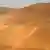 A man stands in an endless sandy desert