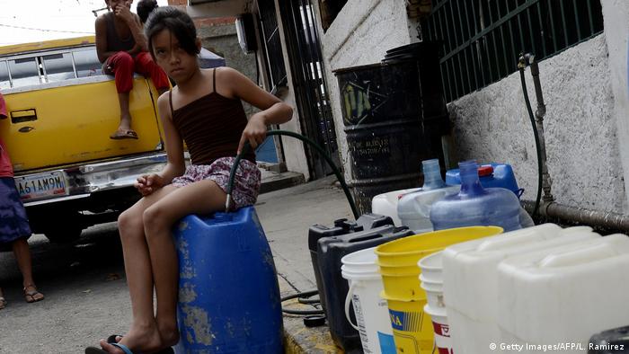 Una niña en Caracas carga agua en un bidón para llevarla a su casa. (Archivo).