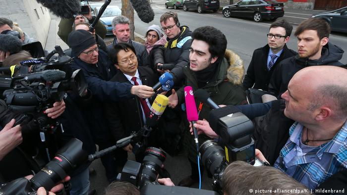 Anas M., who became the victim of an anti-refugee smear campaign on Facebook after taking a selfie with Chancellor Angela Merkel, speaks to reporters outside a courthouse in Bavaria.