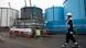 An employee walks past storage tanks for contaminated water at the Fukushima nuclear power plant in Okuma, Japan An employee walks past storage tanks for contaminated water at the Fukushima nuclear power plant in Okuma, Japan