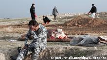 Ein irakischer Polizist reagiert emotional bei der Bergung von Leichen aus einem Massengrab in Mossul, Irak, am 15.03.2017. Vor Kurzem erst war die Terrormiliz Islamischer Staat (IS) aus diesem Gebiet vertrieben worden. Immer mehr Menschen fliehen vor den heftigen Kämpfen um die nordirakische IS-Hochburg Mossul. Foto: Christian Stephen/AP/dpa +++(c) dpa - Bildfunk+++ |