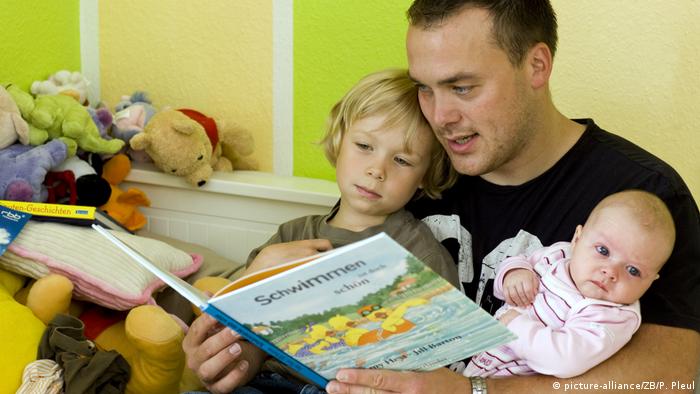 Vater liest Kindern aus einem Buch vor