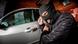 A thief breaks into a car A thief breaks into a car