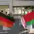Женщины держат в руках флаги Германии и Беларуси