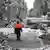 A rescue worker stands on a street that is blocked by falled trees