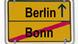 Das Wort 'Berlin' mit einem von unten nach oben zeigenden Pfeil dahinter symbolisiert den Umzug vom Rhein an die Spree. Unter einer schwarzen Linie steht das Wort 'Bonn'. Das Schild ist eine Foto-Montage in der Typographie eines gelben Ortschildes (Foto: DW) Das Wort 'Berlin' mit einem von unten nach oben zeigenden Pfeil dahinter symbolisiert den Umzug vom Rhein an die Spree. Unter einer schwarzen Linie steht das Wort 'Bonn'. Das Schild ist eine Foto-Montage in der Typographie eines gelben Ortschildes (Foto: DW)