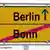 Das Wort 'Berlin' mit einem von unten nach oben zeigenden Pfeil dahinter symbolisiert den Umzug vom Rhein an die Spree. Unter einer schwarzen Linie steht das Wort 'Bonn'. Das Schild ist eine Foto-Montage in der Typographie eines gelben Ortschildes (Foto: DW)