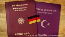 ***Symbolbild***
Deutscher und tuerkischer Pass mit verbindender Deutschlandfahne, doppelte Staatsbuergerschaft | German passport an Turkish passport, dual citizenship | Verwendung weltweit