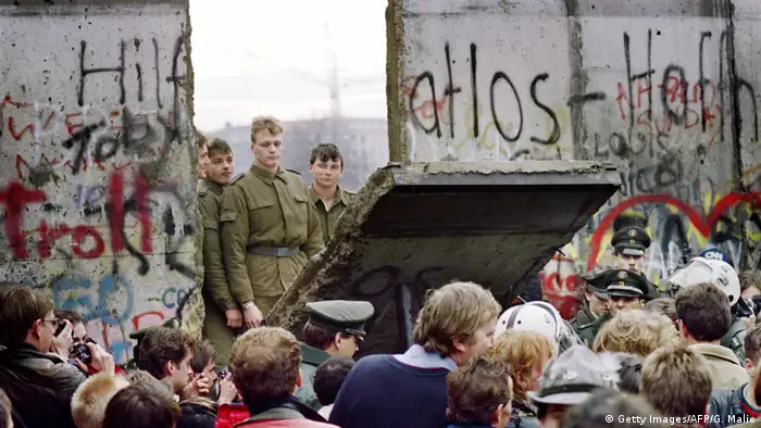 West Berliners crowd in front of the Berlin Wall early November 11, 1989 as they watch East German border guards demolishing a section of the wall. 
