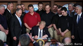 US President Donald Trump signs an executive order at the Environmental Protection Agency (EPA) pushing back against the Obama administration's climate change regulations