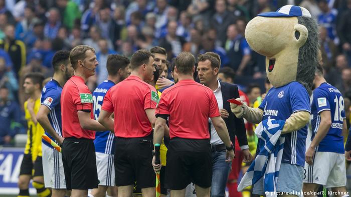Schalke mascot Erwin holds up the red card