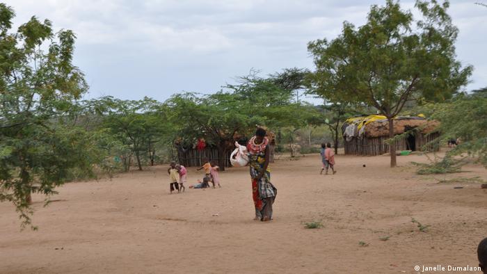 Sandy ground with huts and the children in the background