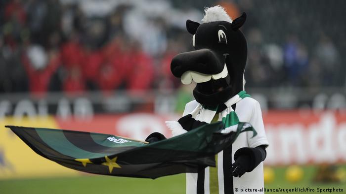 Fußballmaskottchen im Pferdekostüm mit Fahne in der Hand (picture-alliance/augenklick/firo Sportphoto)