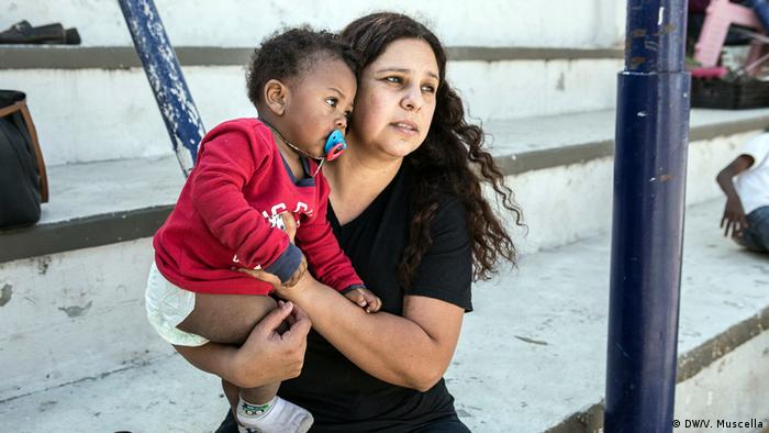 Pastor's wife Alvidrez holds a Haitian child in her arms at the Emmanuel Baptist Center in Tijuana