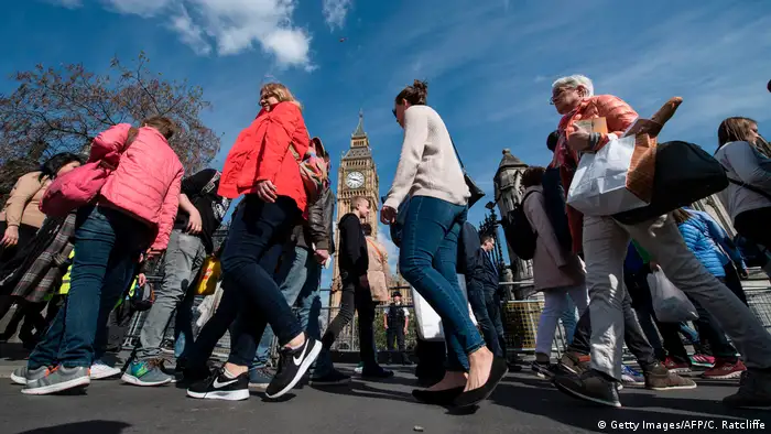 Tourists walk past Big Ben in London