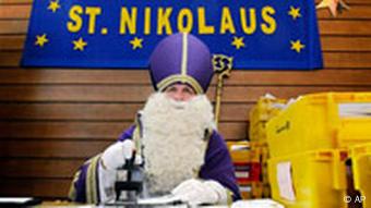 Der Nikolaus aus der saarlaendischen Gemeinde St. Nikolaus, Rudolf Lange, stempelt bei der Eroeffnung des Sonderpostamtes mit dem Nikolaus-Sonderstempel der Post. Quelle: ap