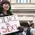 Eine Frau hält ein Schild in der Hand mit der Aufschrift "Science is sexy" 