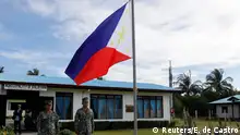 Filipino soldiers stand at attention near a Philippine flag at Thitu island in disputed South China Sea April 21, 2017. REUTERS/Erik De Castro