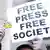 A protester in Turkey holding a sign that reads Free Press Free Society