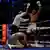 Боксер Владимир Кличко пытается встать, его соперник Энтони Джошуа радуется победе