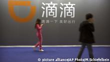 Visitors walk past a sign for Chinese ride-hailing service Didi Chuxing at the Global Mobile Internet Conference (GMIC) in Beijing, Thursday, April 27, 2017. The GMIC features current and future trends in the mobile Internet industry by some major foreign and Chinese internet companies. (AP Photo/Mark Schiefelbein) |