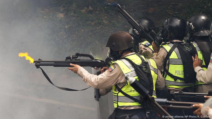 Agentes policiales lanzan gases lacrimógenos contra manifestantes.