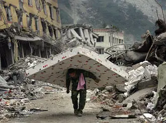 A Chinese man carries a mattress he removed from a destroyed apartment in Yingxiu in Wenchuan County of southwest China's Sichuan province Tuesday, May 27, 2008. The number of deaths from the quake has climbed further toward an expected toll of 80,000 or more. The Cabinet said Tuesday that 67,183 people were confirmed killed _ up by about 2,000 from a day earlier _ and 20,790 were sill missing.(AP Photo/David Guttenfelder)