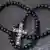 schwarze Perlenkette mit Kruzifix auf Ölschieferplatte