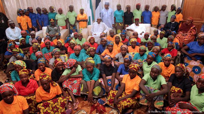 El presidente nigeriano, Muhammadu Buhari, y las muchachas liberadas.