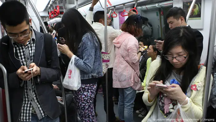 China Menschen mit Smartphones in der Metro in Hangzhou