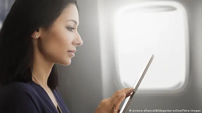 Junge Frau, die Tablet im Flugzeug verwendet (picture alliance/Bildagentur-online/Tetra Images)