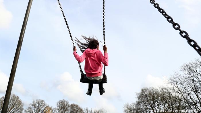 A young girl playing on a swing 