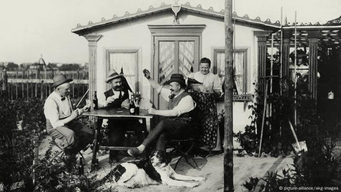 Drei Männer spielen vor einer Gartenhütte Skat am Tisch. (Foto: picture-alliance/akg-images)
