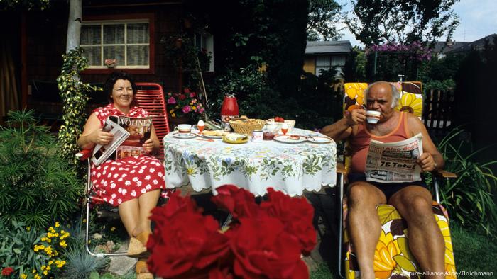 Ein Paar sitzt an einem gedeckten Tisch im Schrebergarten (Foto: picture-alliance/dpa/Brüchmann)