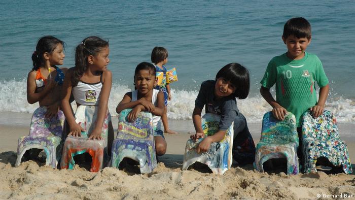 Niños mexicanos presentan en una playa las sillas que elaboraron a partir de polietileno reciclado.